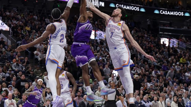 Jan 18, 2024; Salt Lake City, Utah, USA; Utah Jazz guard Collin Sexton (2) dunks the ball between Oklahoma City Thunder guard Shai Gilgeous-Alexander (2) and forward Chet Holmgren (7) during the second half at Delta Center.